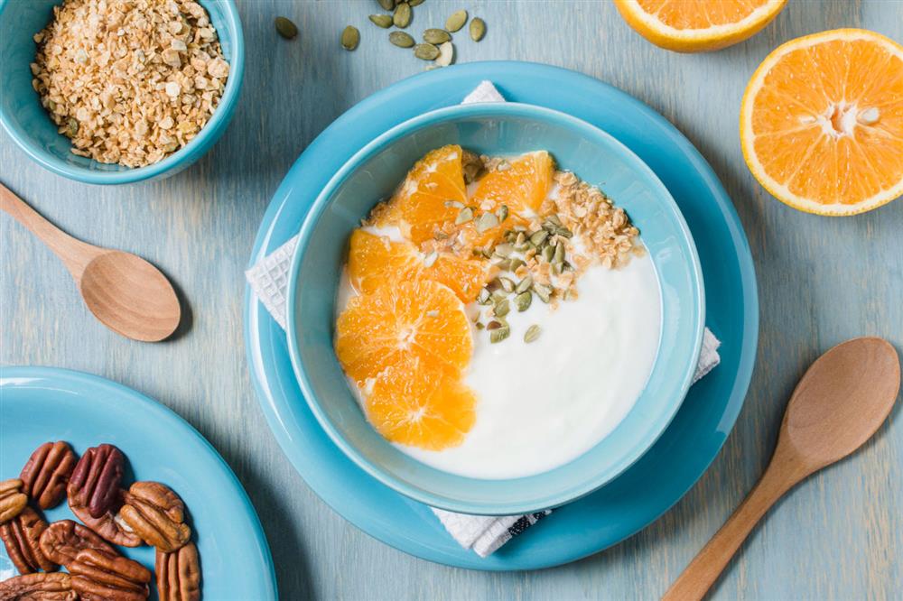 A bowl of breakfast cream with nuts and pieces of fruit